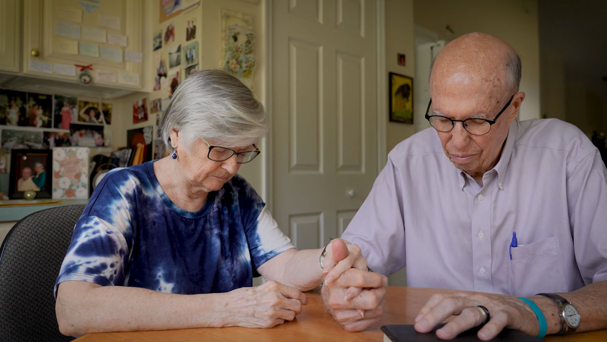 Steve and Linda Sheldon praying together.